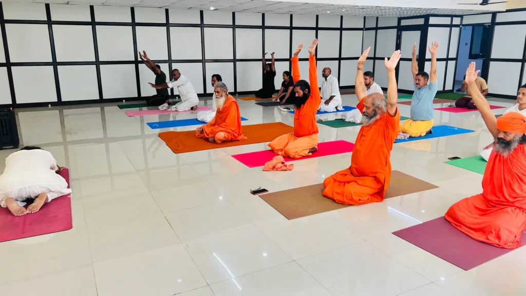 Group yoga class with practitioners and monks at Jahnavi Wellness Yoga Hall